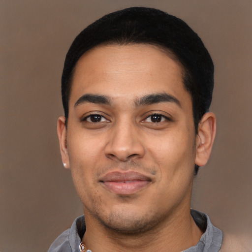 Joyful latino young-adult male with short  black hair and brown eyes