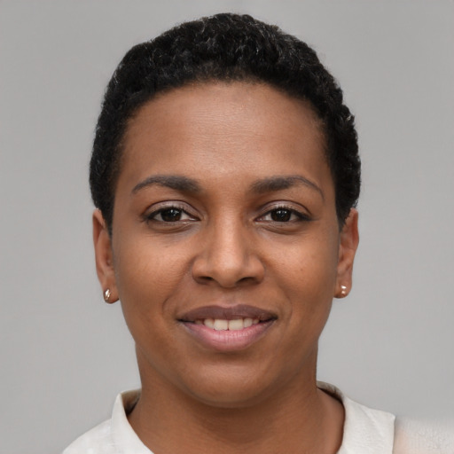 Joyful black young-adult female with short  black hair and brown eyes