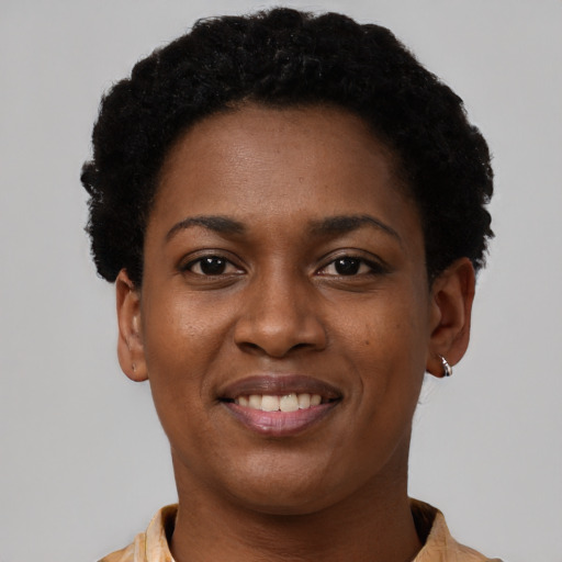 Joyful black young-adult female with short  black hair and brown eyes
