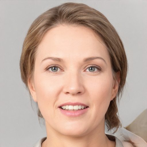 Joyful white young-adult female with medium  brown hair and grey eyes