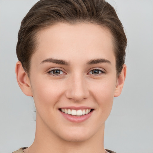 Joyful white young-adult female with short  brown hair and grey eyes