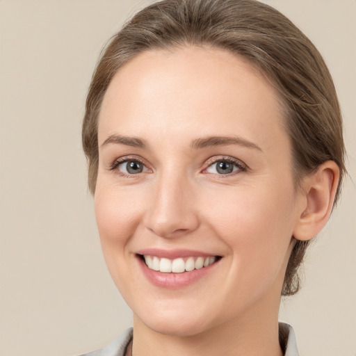 Joyful white young-adult female with medium  brown hair and grey eyes