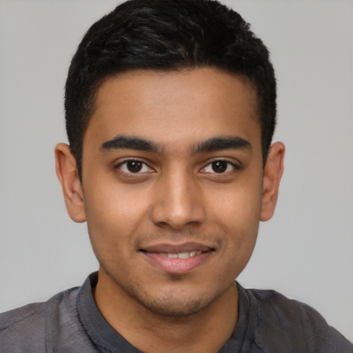 Joyful latino young-adult male with short  black hair and brown eyes