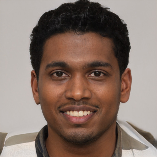 Joyful black young-adult male with short  black hair and brown eyes