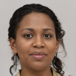 Joyful black adult female with medium  brown hair and brown eyes