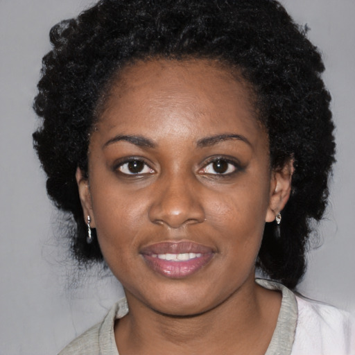 Joyful black young-adult female with medium  black hair and brown eyes