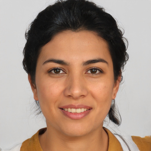 Joyful latino young-adult female with medium  brown hair and brown eyes