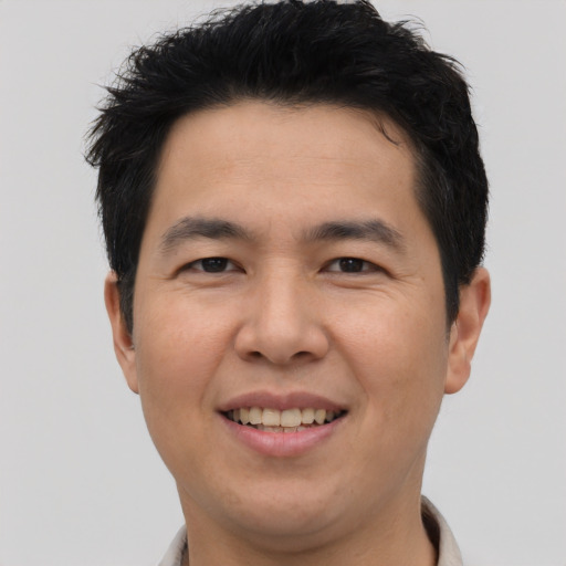 Joyful asian young-adult male with short  brown hair and brown eyes