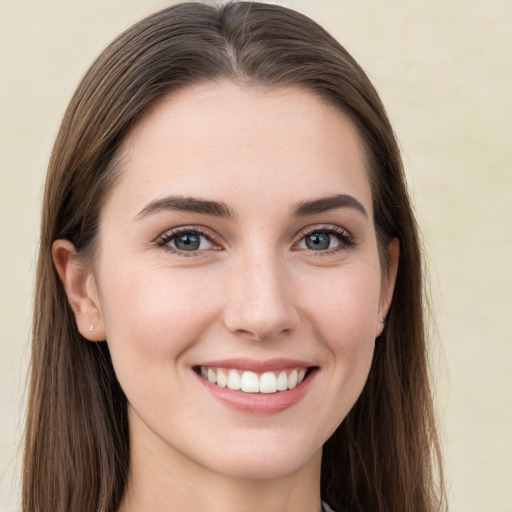 Joyful white young-adult female with long  brown hair and grey eyes