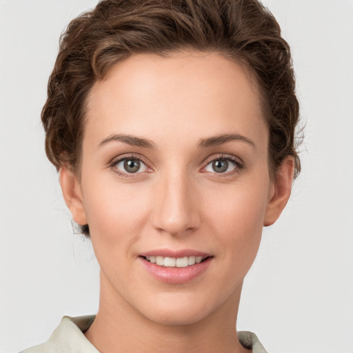 Joyful white young-adult female with short  brown hair and grey eyes