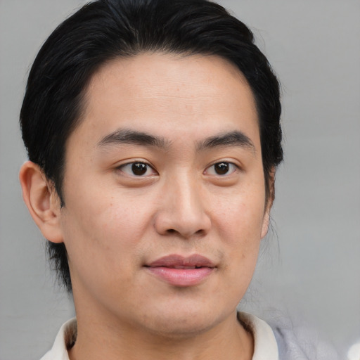 Joyful asian young-adult male with short  brown hair and brown eyes