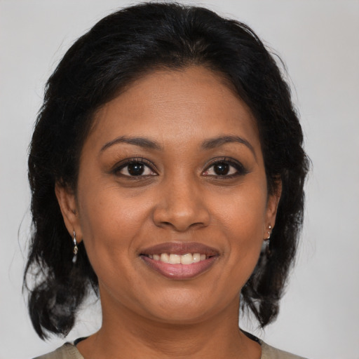Joyful black adult female with medium  brown hair and brown eyes