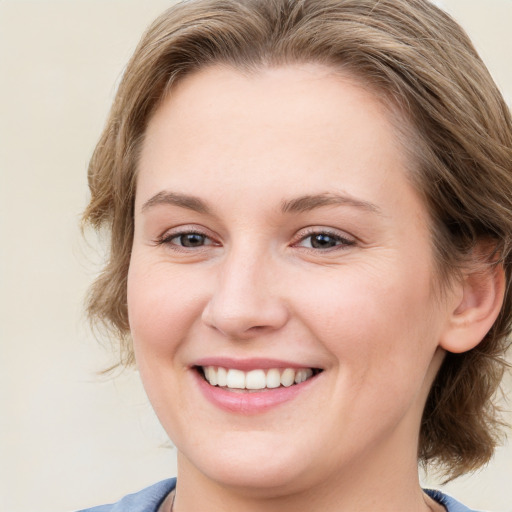 Joyful white young-adult female with medium  brown hair and blue eyes