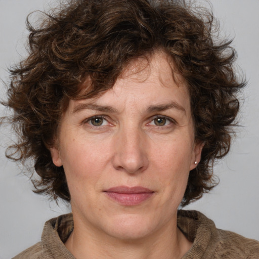 Joyful white adult female with medium  brown hair and green eyes