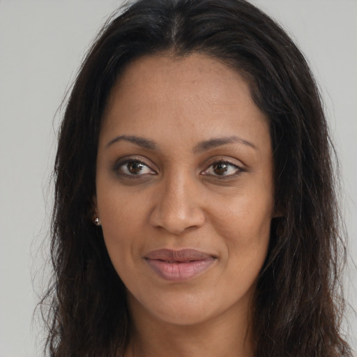 Joyful black young-adult female with long  brown hair and brown eyes