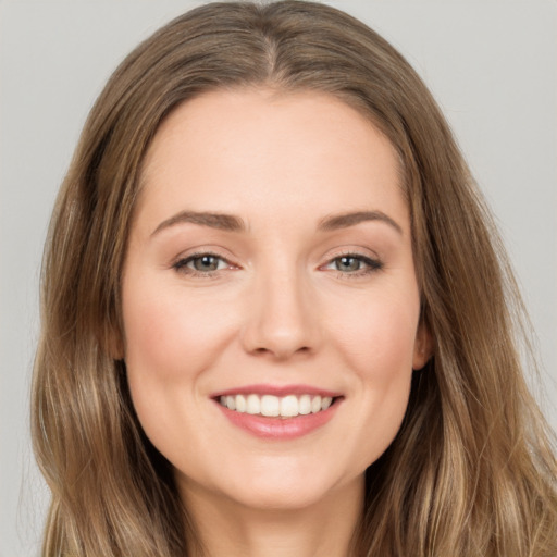 Joyful white young-adult female with long  brown hair and brown eyes