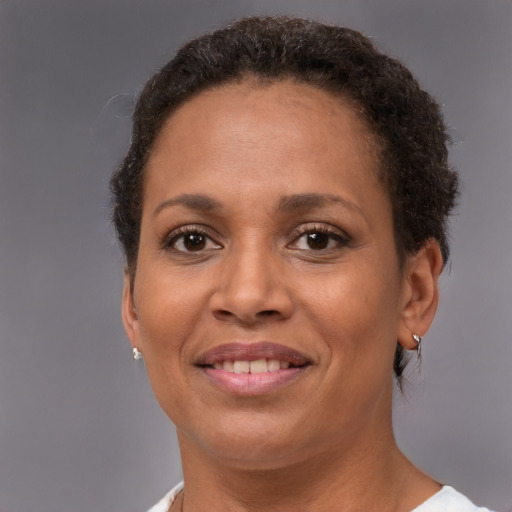 Joyful black adult female with short  brown hair and brown eyes