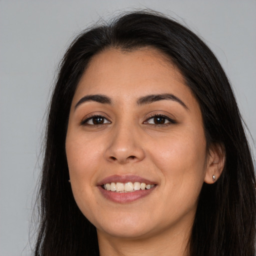 Joyful latino young-adult female with long  brown hair and brown eyes