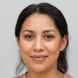 Joyful latino young-adult female with medium  brown hair and brown eyes