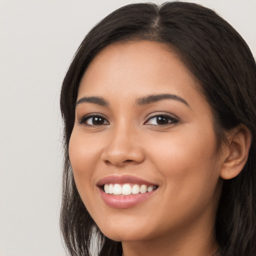 Joyful latino young-adult female with long  black hair and brown eyes