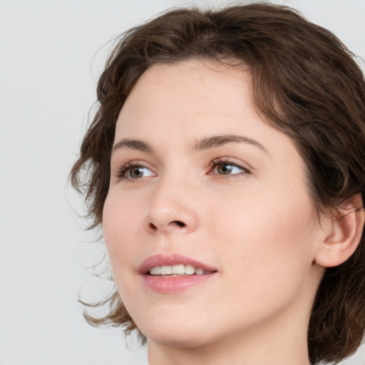 Joyful white young-adult female with medium  brown hair and green eyes