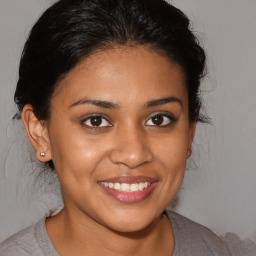 Joyful latino young-adult female with medium  brown hair and brown eyes