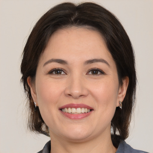 Joyful white adult female with medium  brown hair and brown eyes