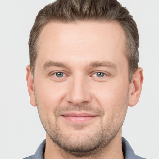 Joyful white young-adult male with short  brown hair and grey eyes