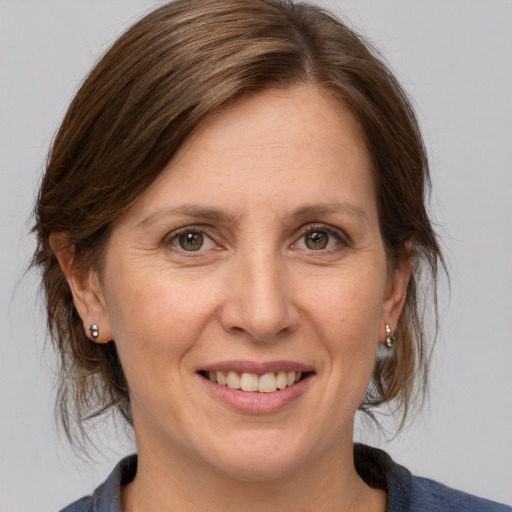 Joyful white adult female with medium  brown hair and grey eyes