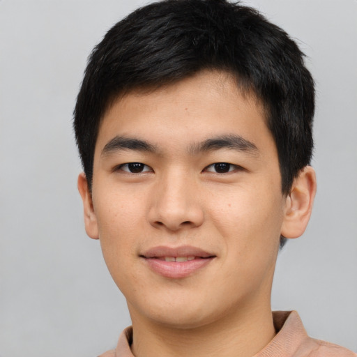 Joyful asian young-adult male with short  brown hair and brown eyes