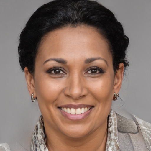 Joyful latino adult female with medium  brown hair and brown eyes