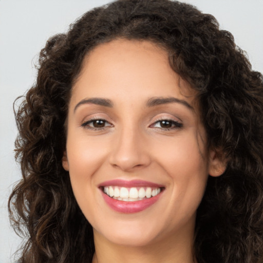 Joyful white young-adult female with long  brown hair and brown eyes