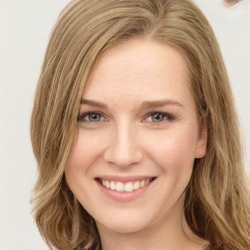 Joyful white young-adult female with long  brown hair and green eyes