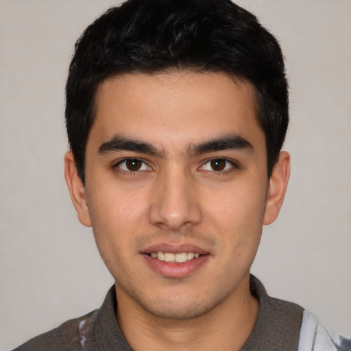 Joyful white young-adult male with short  black hair and brown eyes