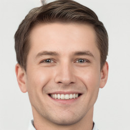 Joyful white young-adult male with short  brown hair and grey eyes