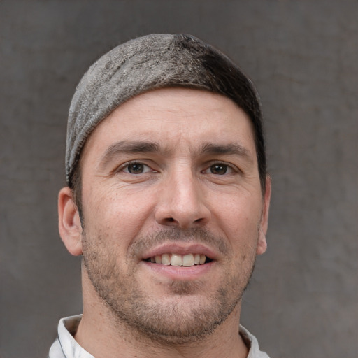 Joyful white adult male with short  brown hair and brown eyes