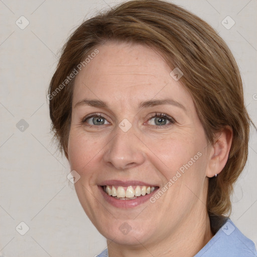 Joyful white adult female with medium  brown hair and blue eyes