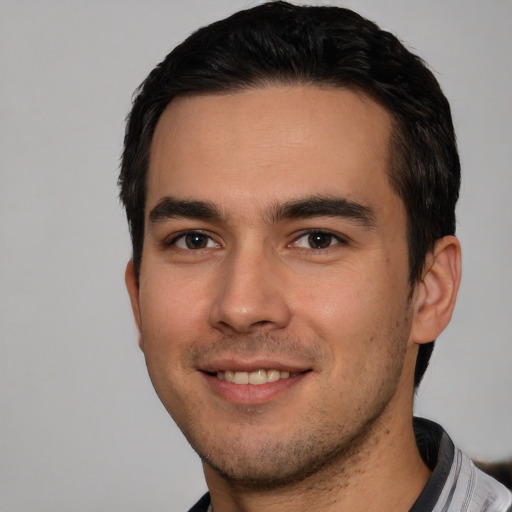 Joyful white young-adult male with short  black hair and brown eyes