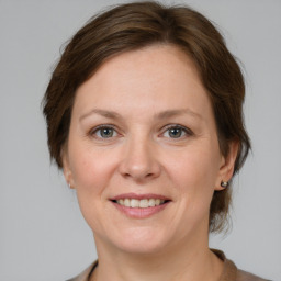 Joyful white adult female with medium  brown hair and grey eyes