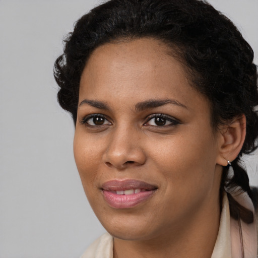 Joyful black young-adult female with long  brown hair and brown eyes
