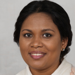 Joyful black adult female with medium  brown hair and brown eyes