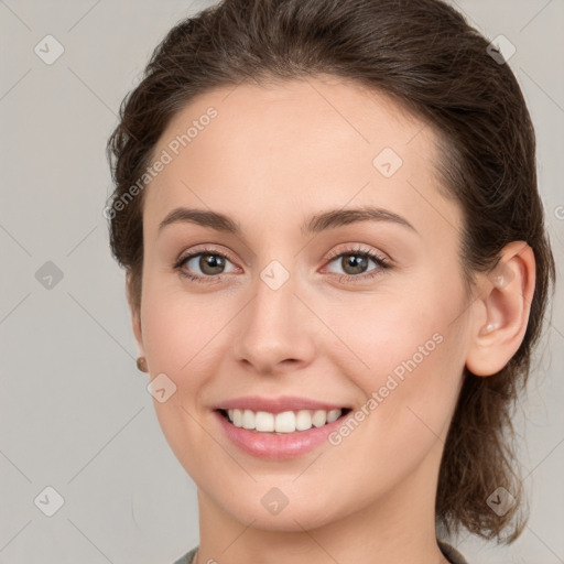 Joyful white young-adult female with medium  brown hair and grey eyes