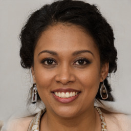 Joyful black young-adult female with long  brown hair and brown eyes