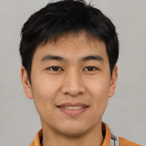 Joyful asian young-adult male with short  brown hair and brown eyes