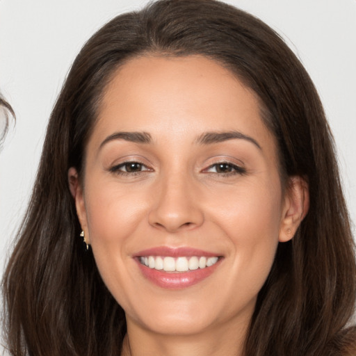 Joyful white young-adult female with long  brown hair and brown eyes