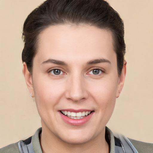 Joyful white young-adult female with short  brown hair and grey eyes