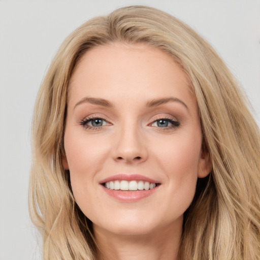 Joyful white young-adult female with long  brown hair and blue eyes