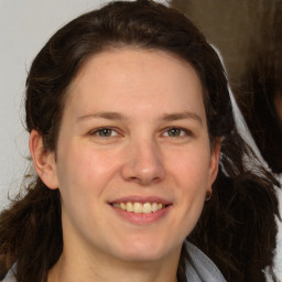 Joyful white young-adult female with long  brown hair and grey eyes