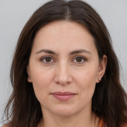 Joyful white adult female with long  brown hair and brown eyes