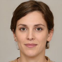 Joyful white young-adult female with medium  brown hair and green eyes